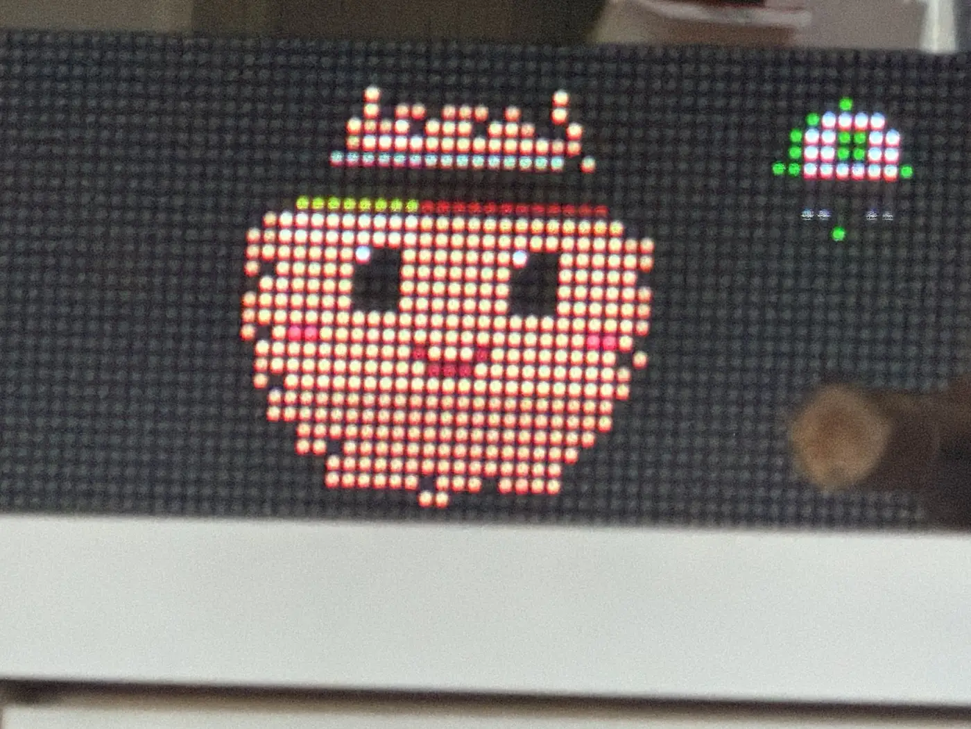 A smiling pixel-art apple lit up on the panel