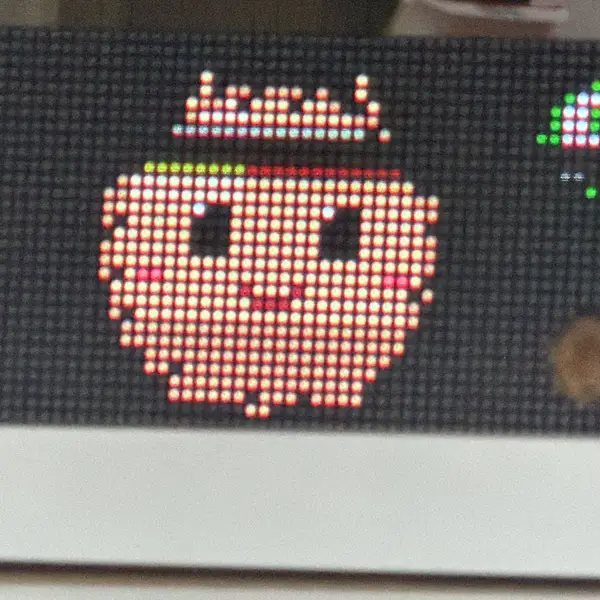 A smiling pixel-art apple lit up on the panel